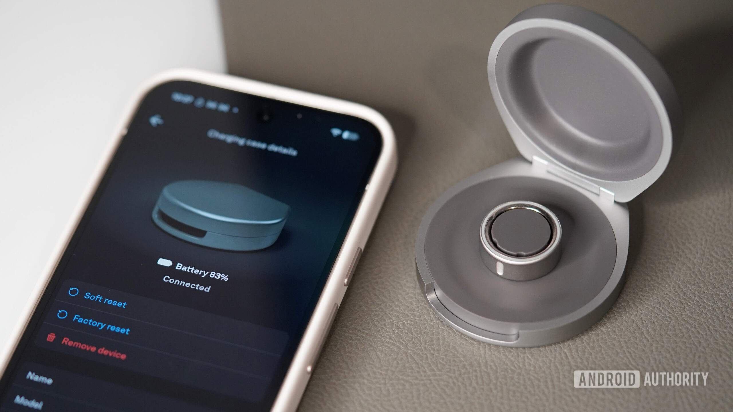 An Oura Ring 4 rests in its Charging Case while the app displays the battery level.