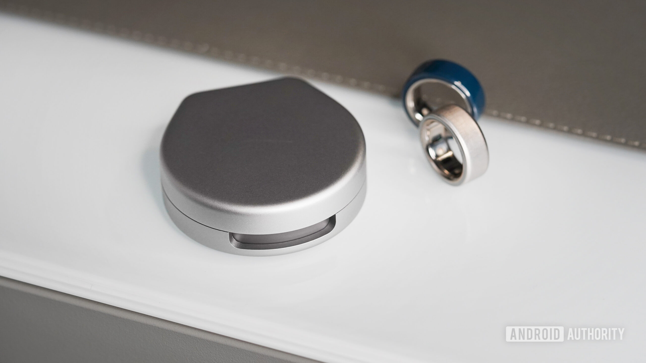 Two Oura Ring 4s rest along side the brand's portable charging case.