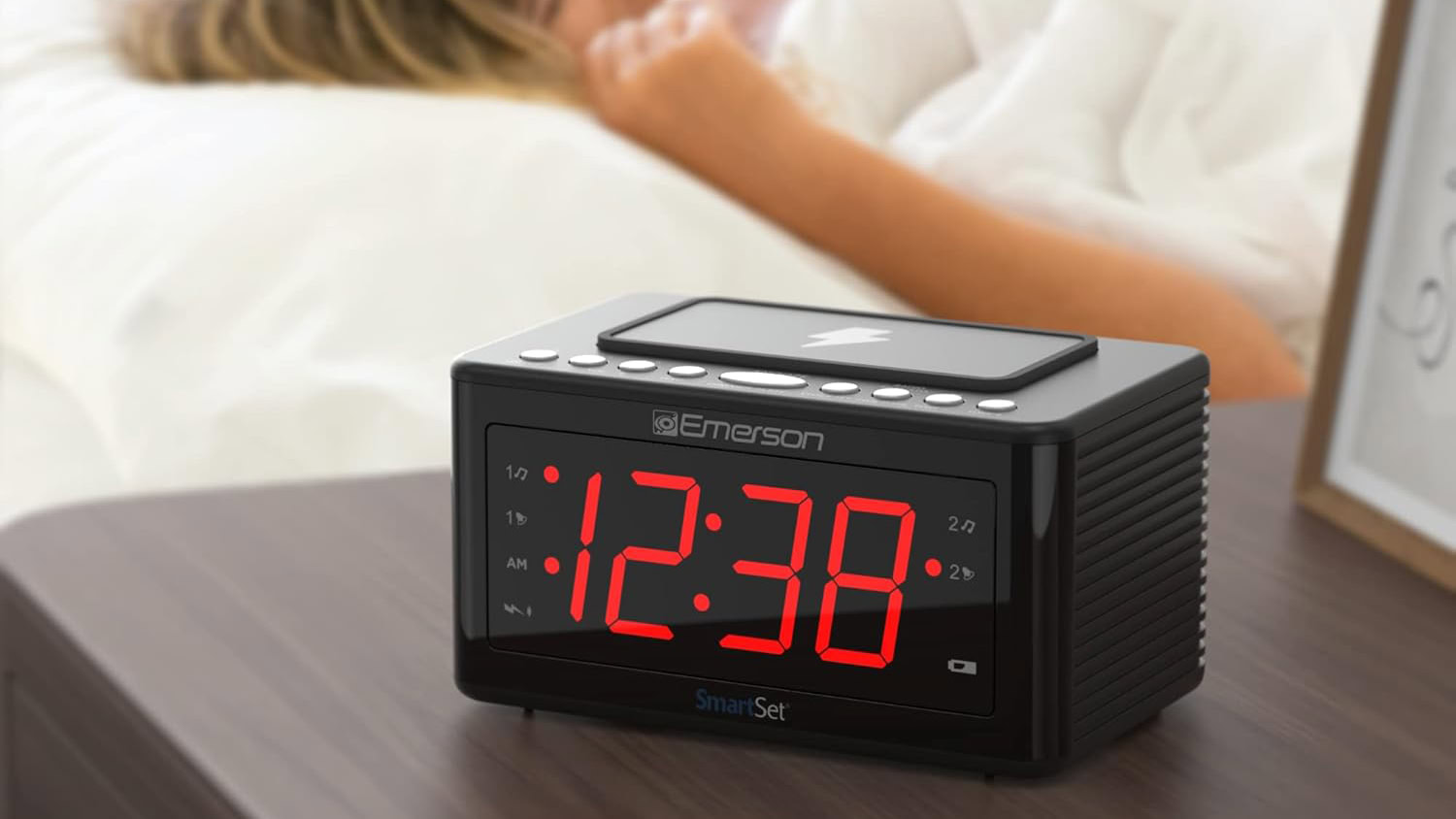 Emerson Smartset Wireless Charging Alarm Clock Radio next to bed and sleeping person Emerson Smartset Wireless Charging Alarm Clock Radio next to bed and sleeping person