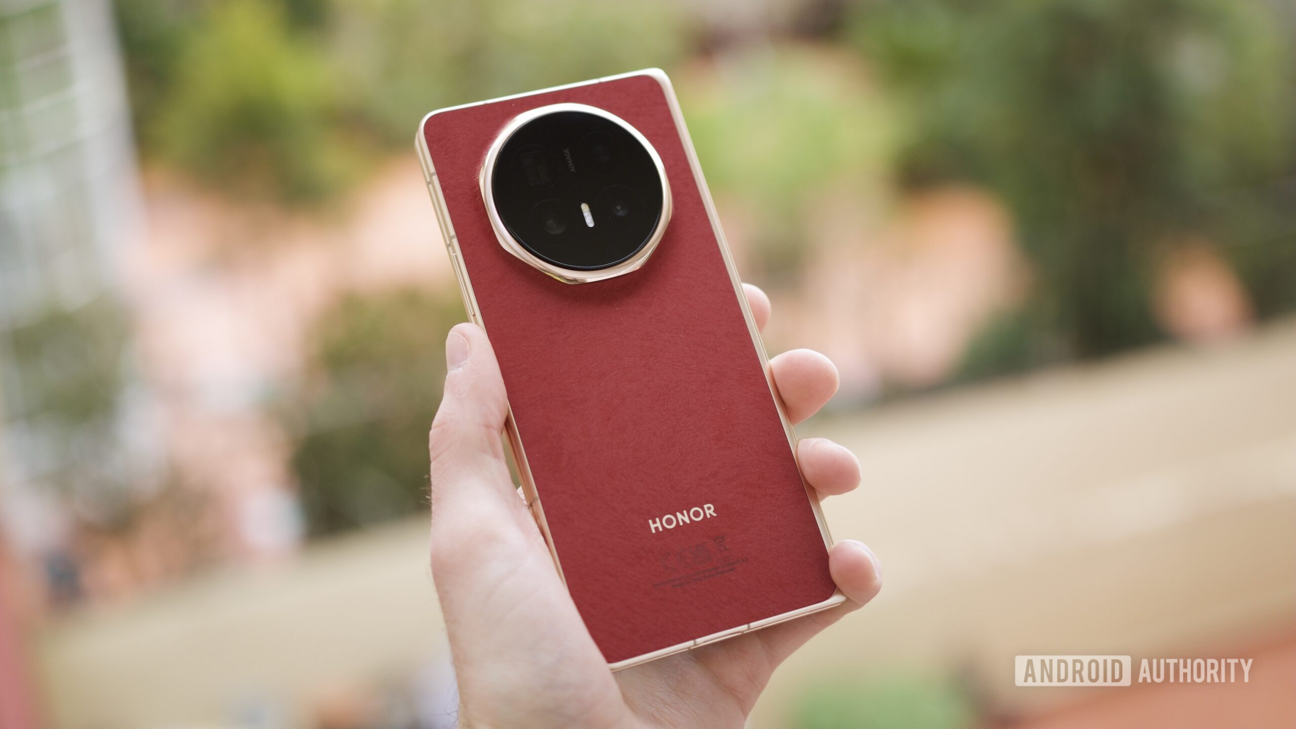 Someone holding the red HONOR Magic V6.