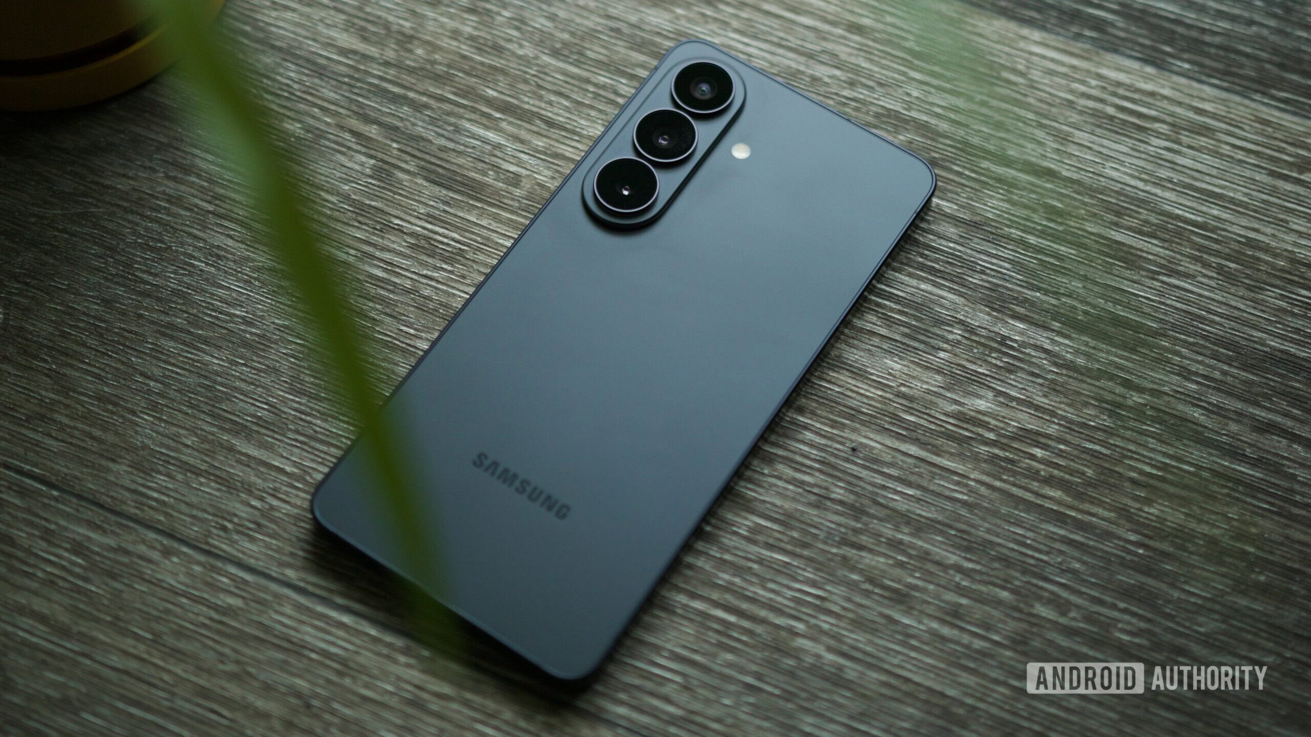 The Samsung Galaxy S26 laying on a wood floor.