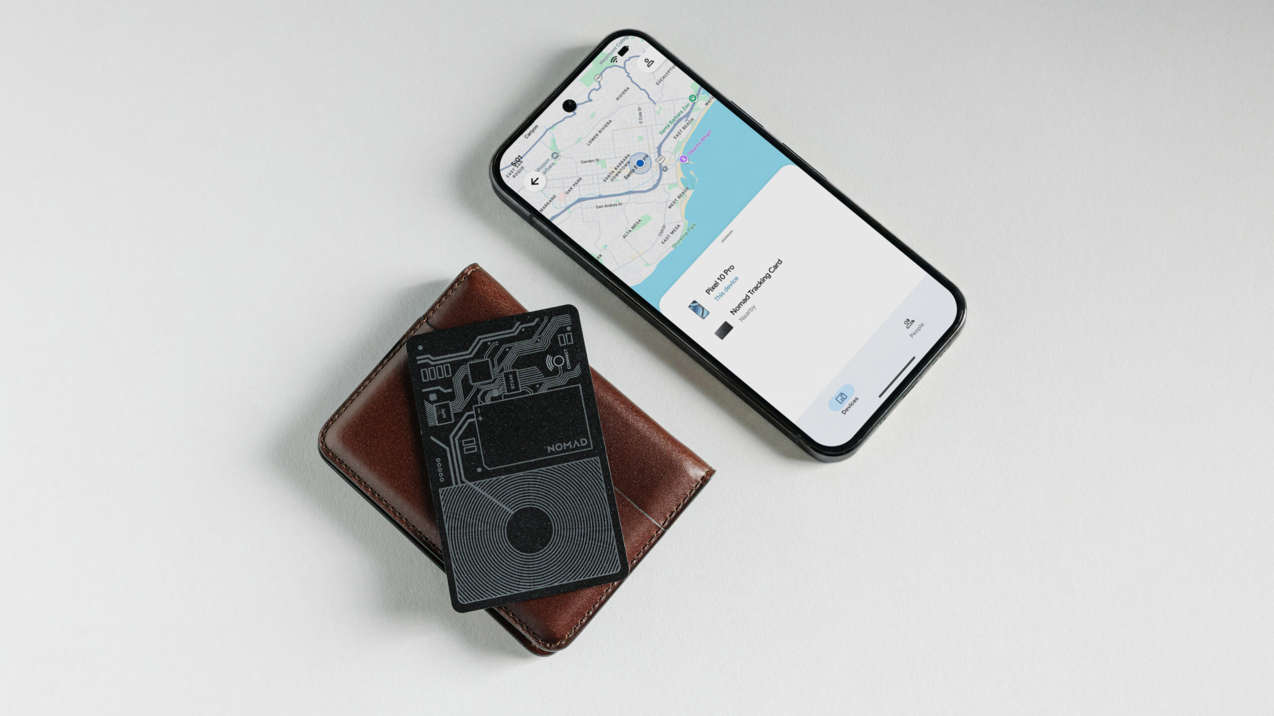 A wallet with a Nomad Tracking Card Air next to a Pixel.