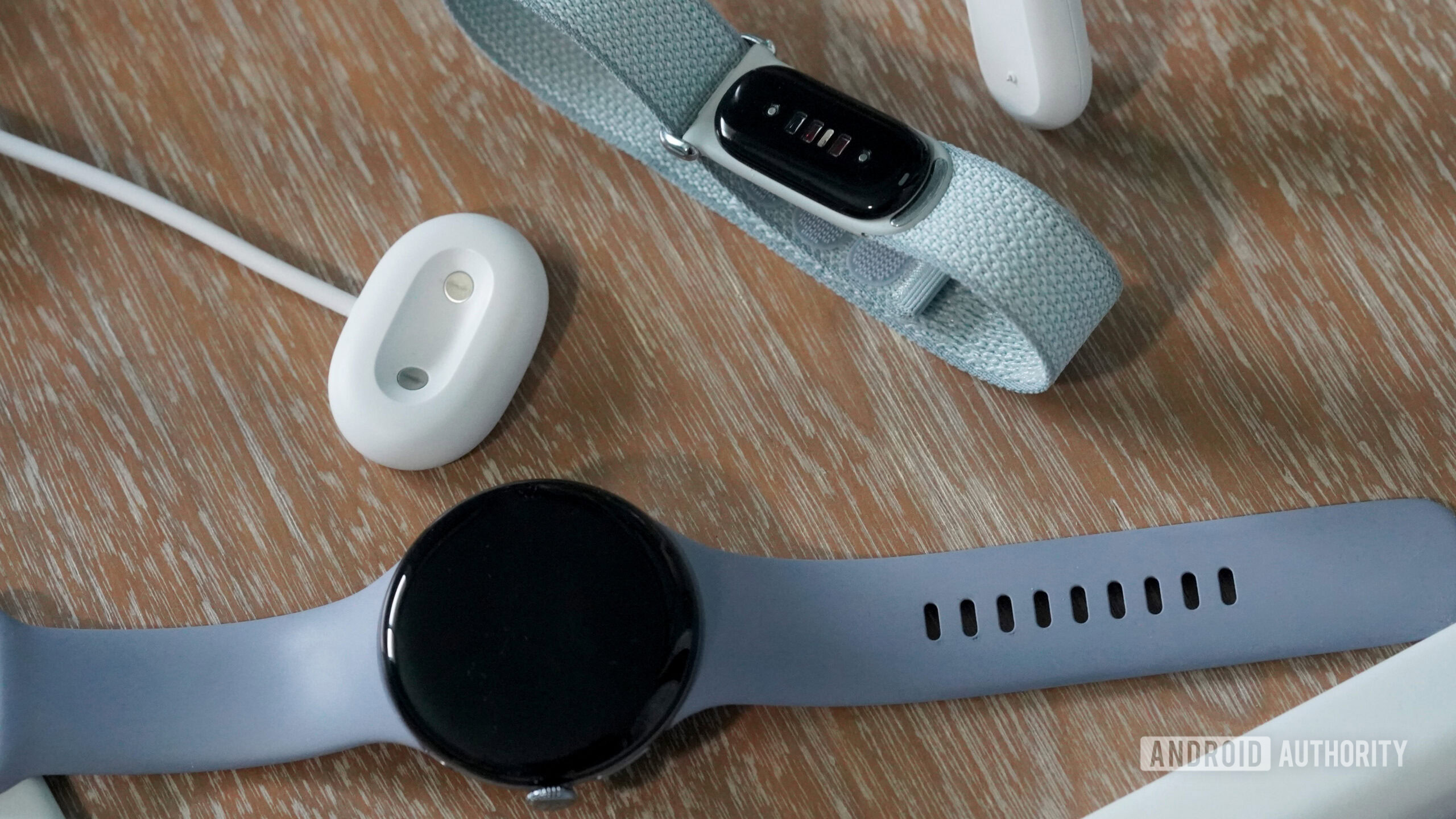 Fitbit Air Pixel Watch 4 Chargers A Fitbit Air and Pixel Watch 4 rest alongside their chargers.