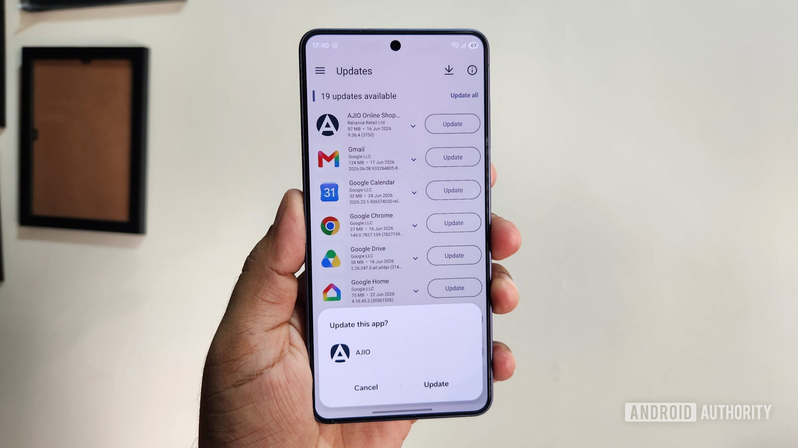 Android phone in hand showing Aurora Store update menu
