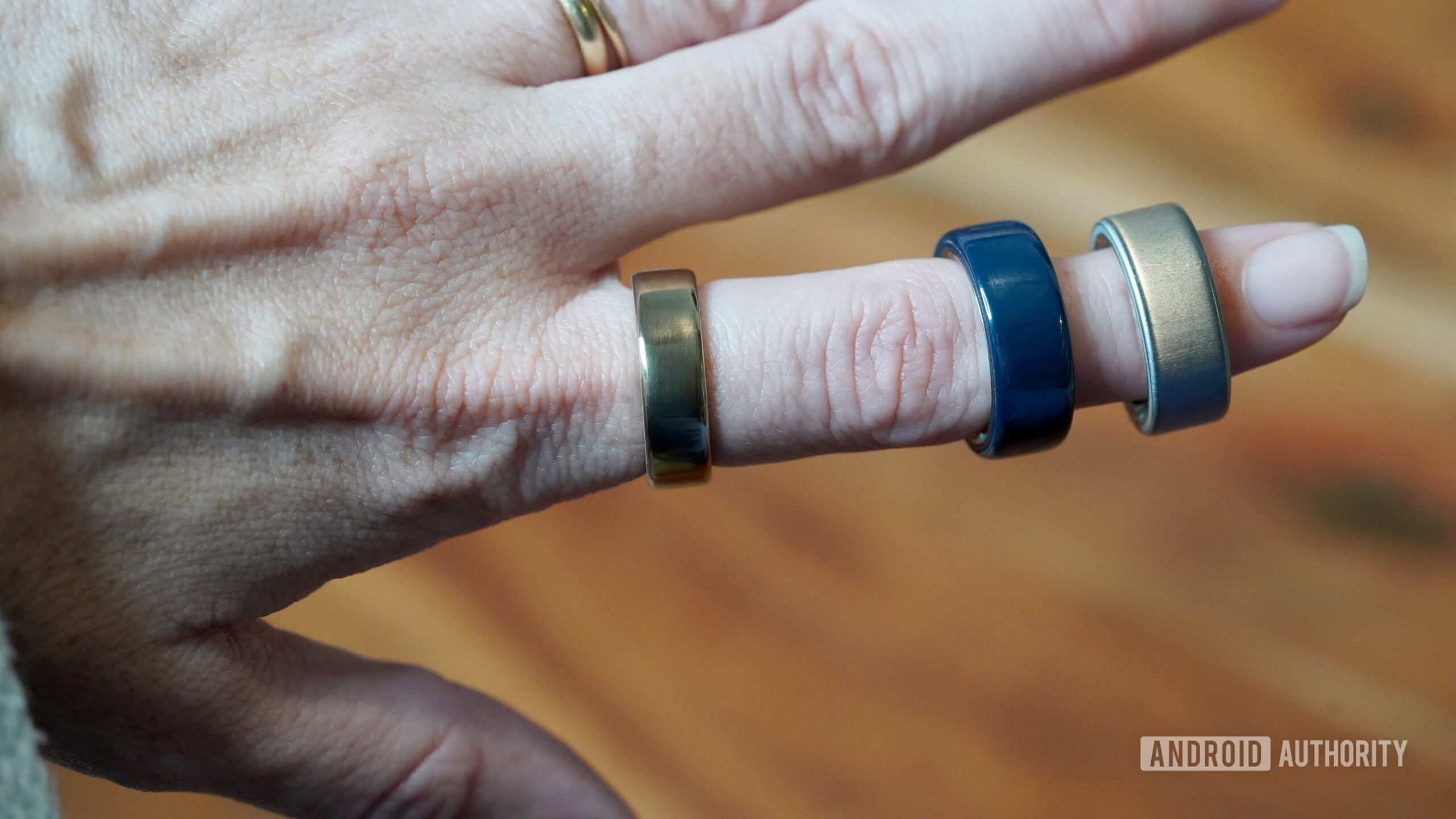 A user wearns Oura Ring 5 along side two Oura Ring 4s.