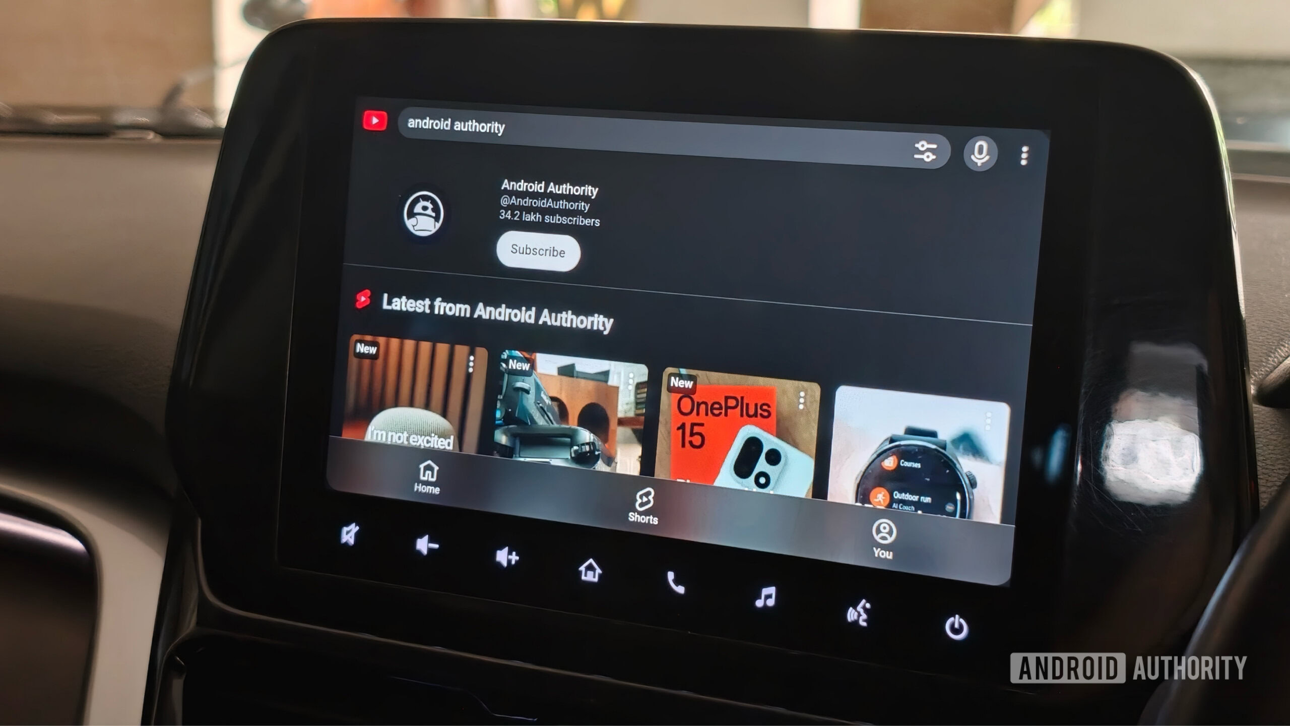 Car infotainment screen displaying the Android Authority YouTube channel homepage running on Android Auto