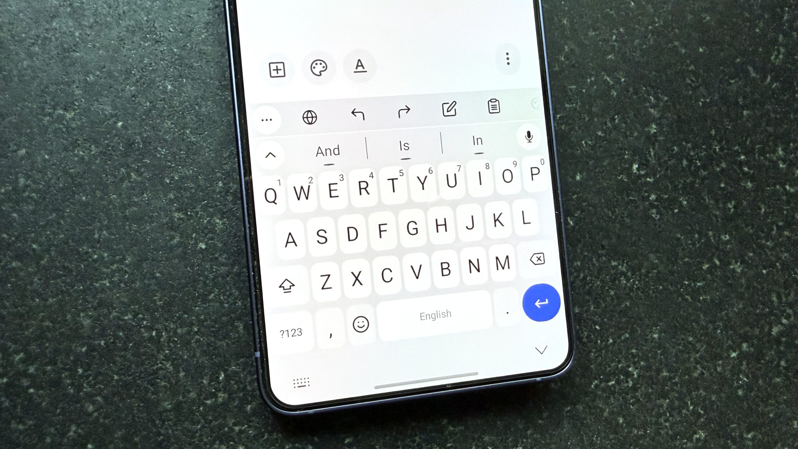 Android phone on a black table top showing FUTO Keyboard