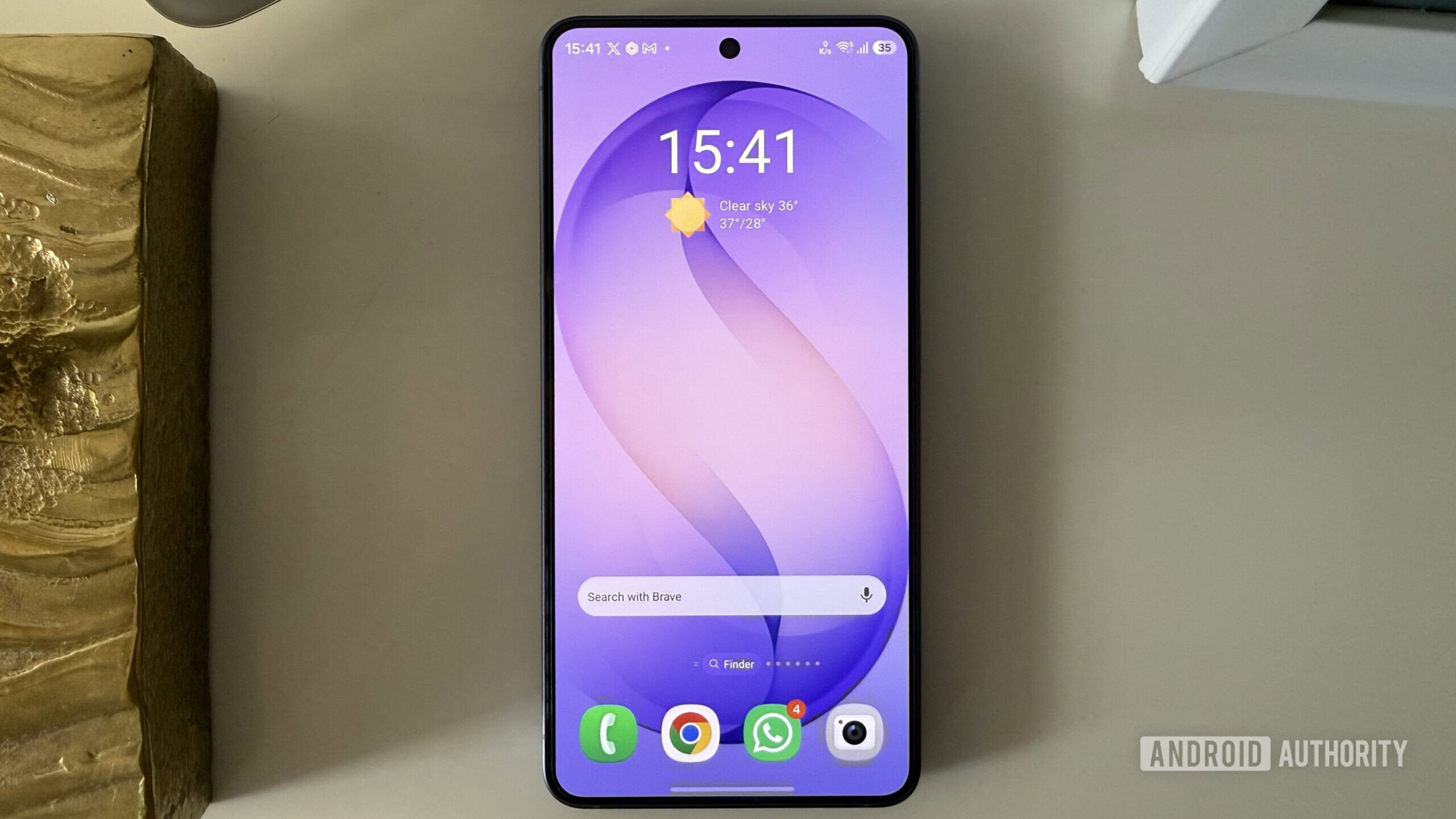 Android phone on a white surface showing home screen widgets
