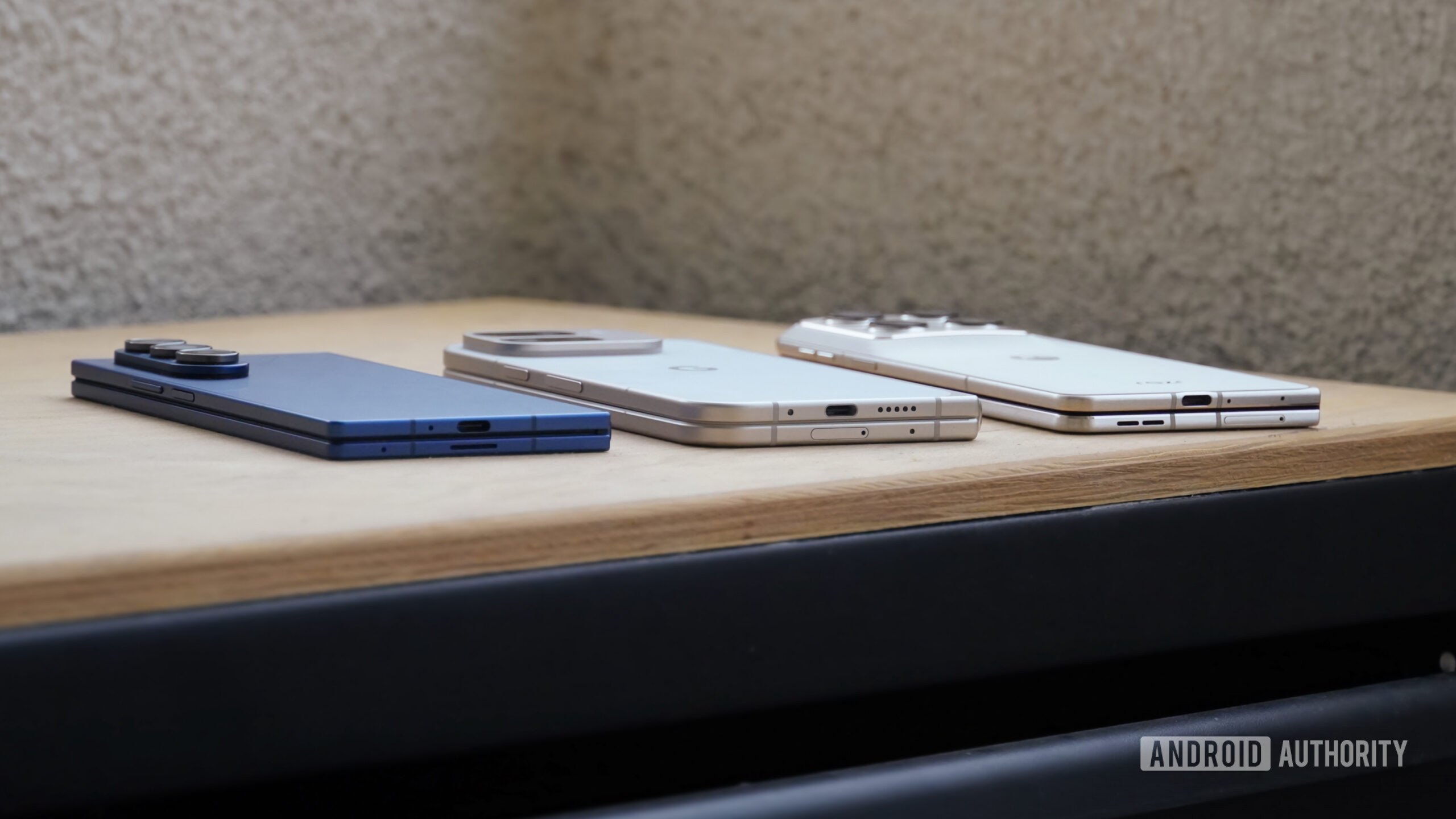 A Pixel 9 Pro Fold in between a Razr Fold and Galaxy Z Fold 7, showing the thickness and ports.