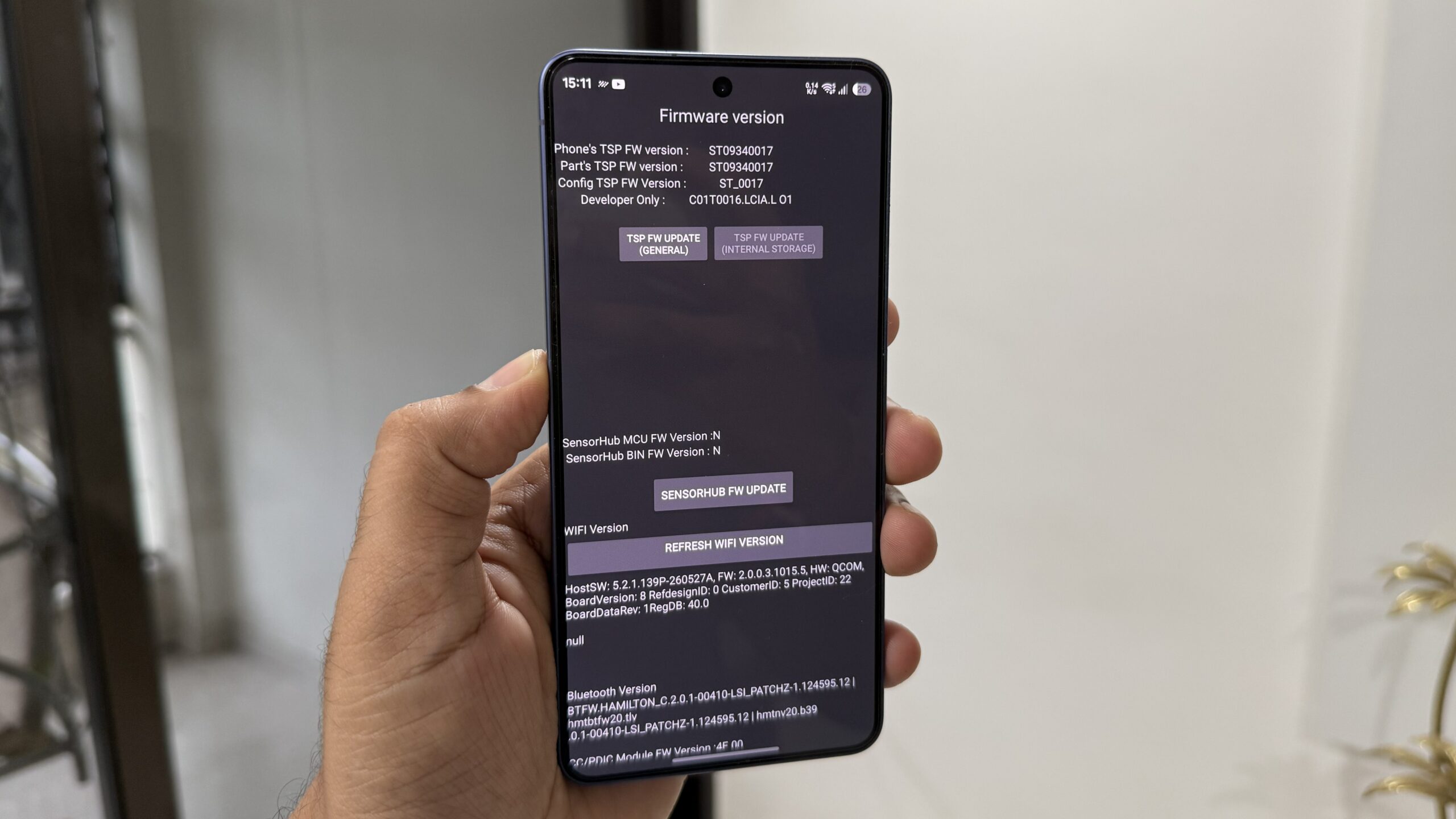 The Samsung phone in his hand shows the software update menu The Samsung phone in his hand shows the software update menu