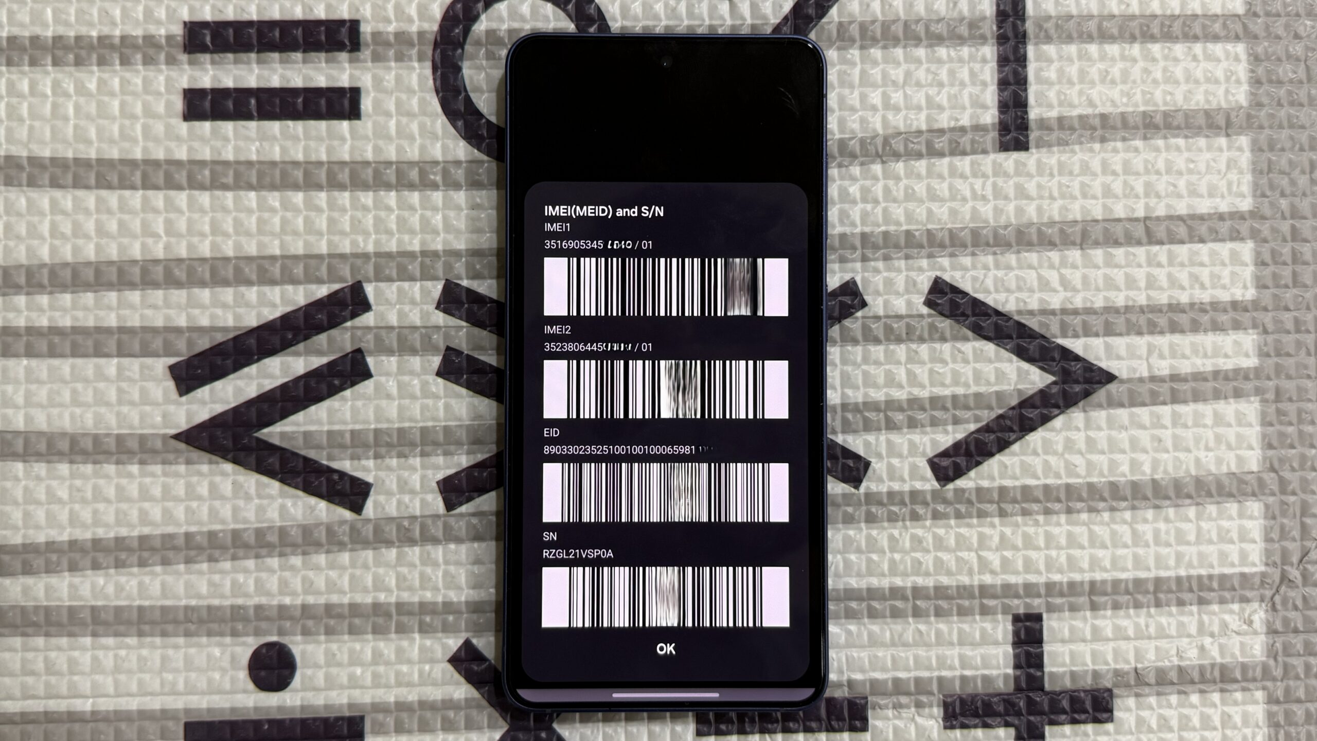 Samsung phone on mat showing IMEI numbers Samsung phone on mat showing IMEI numbers