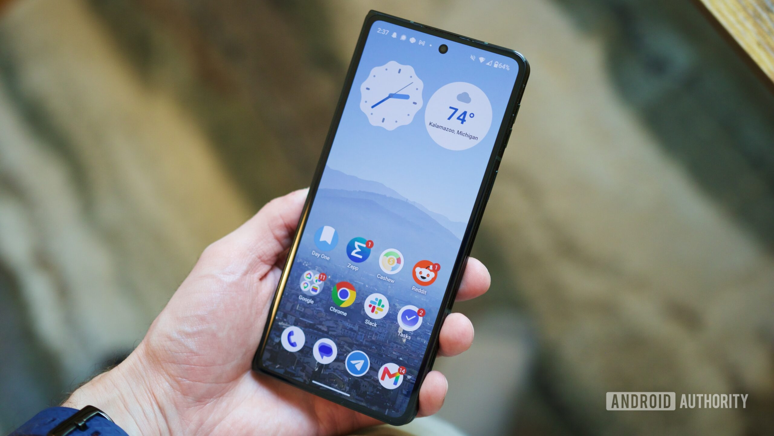 Holding the Motorola Razr Fold with its cover screen on.