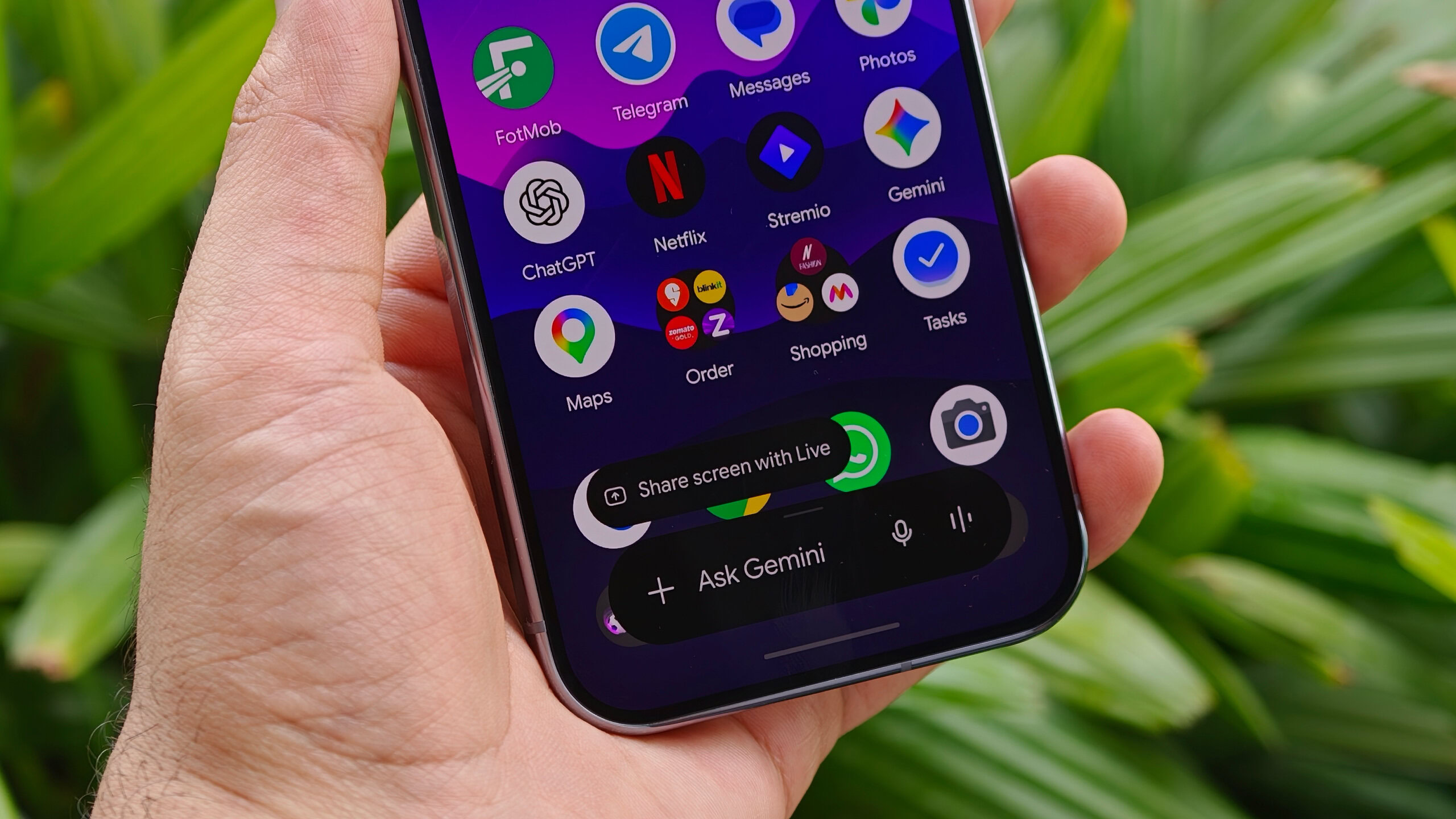 Close-up of a mobile phone screen displaying the home screen layout with a floating "Ask Gemini" AI assistant prompt widget at the bottom