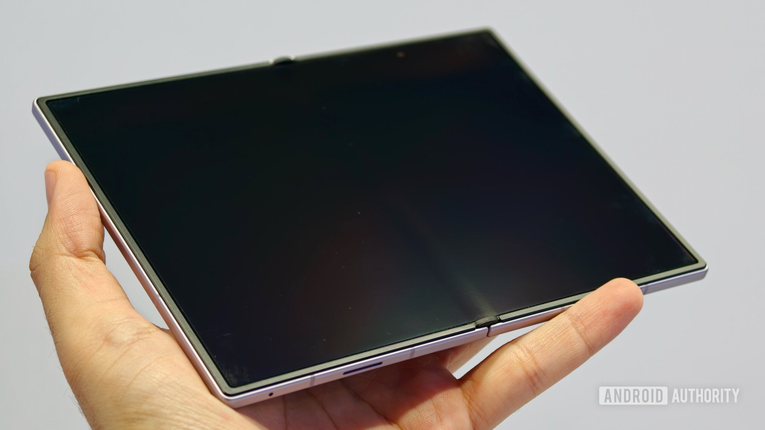A hand holding an unfolded Samsung Galaxy Z Fold 8 with its screen off, showcasing the minimal crease and matte display coating