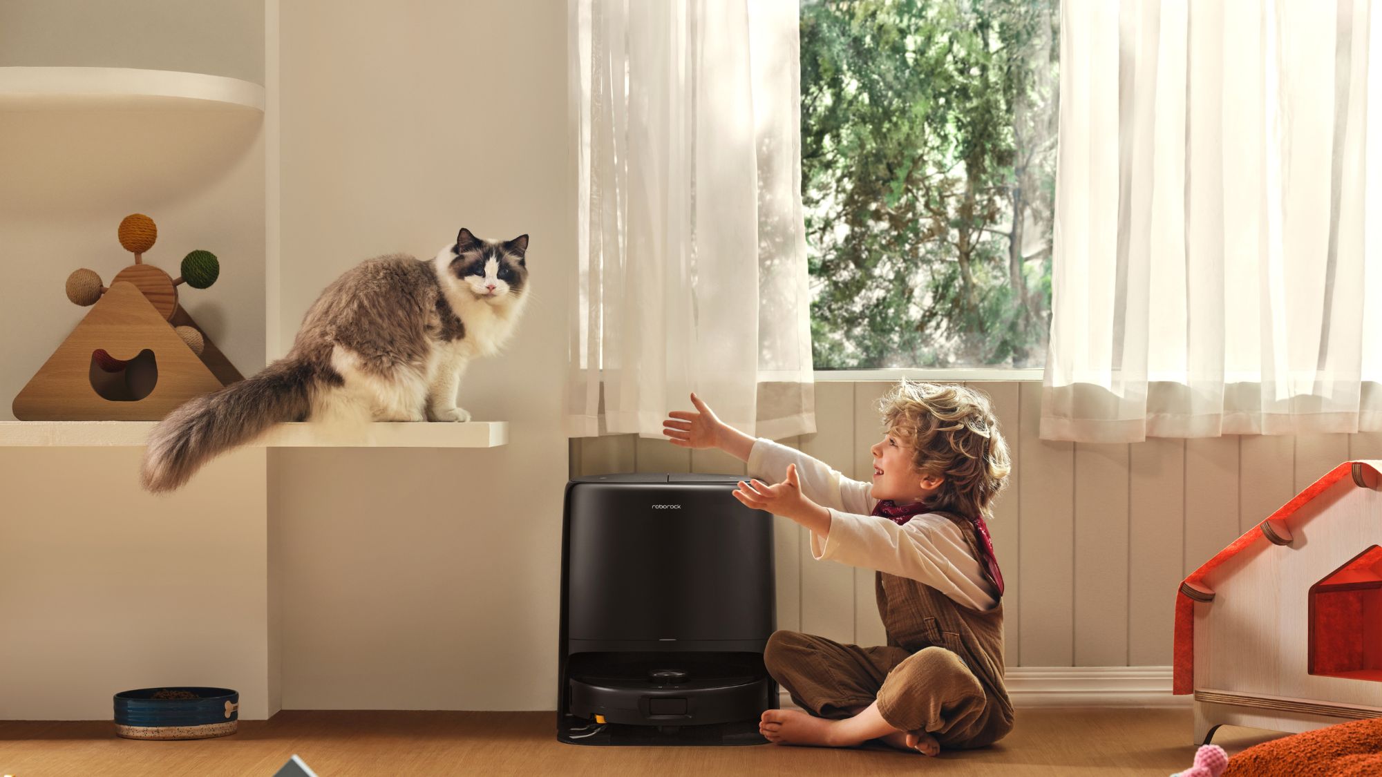 Roborock Qrevo 2 Pro dock station besides a kid and a cat Roborock Qrevo 2 Pro dock station besides a kid and a cat