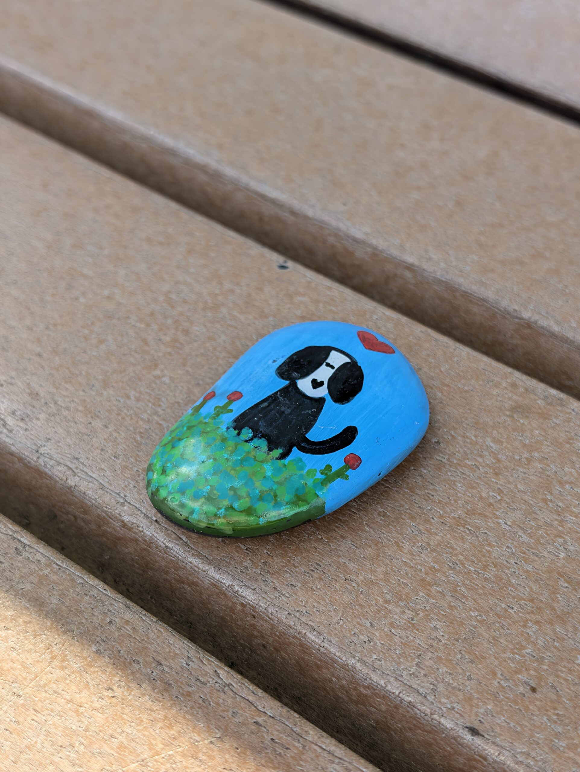 Photo of a painted rock on a bench, taken with the Pixel 11 Pro.