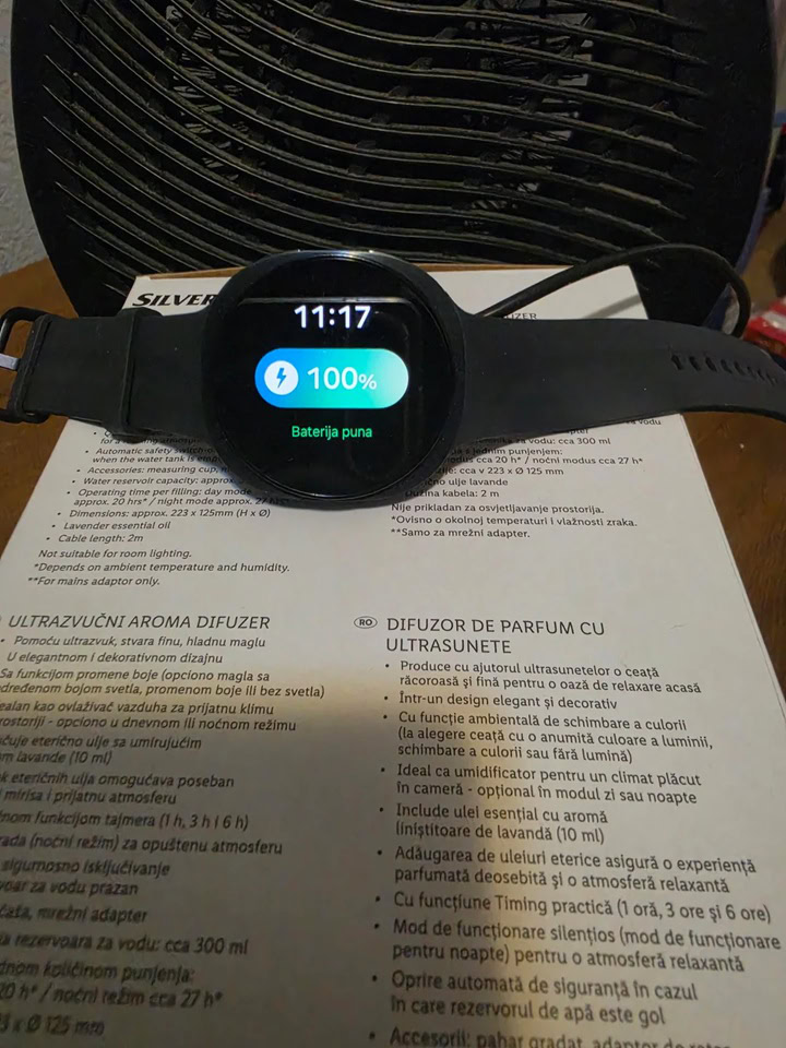 Samsung Galaxy Watch 9 screen showing a 100 percent fully charged battery status at 11:17 AM after using a desk fan for cooling