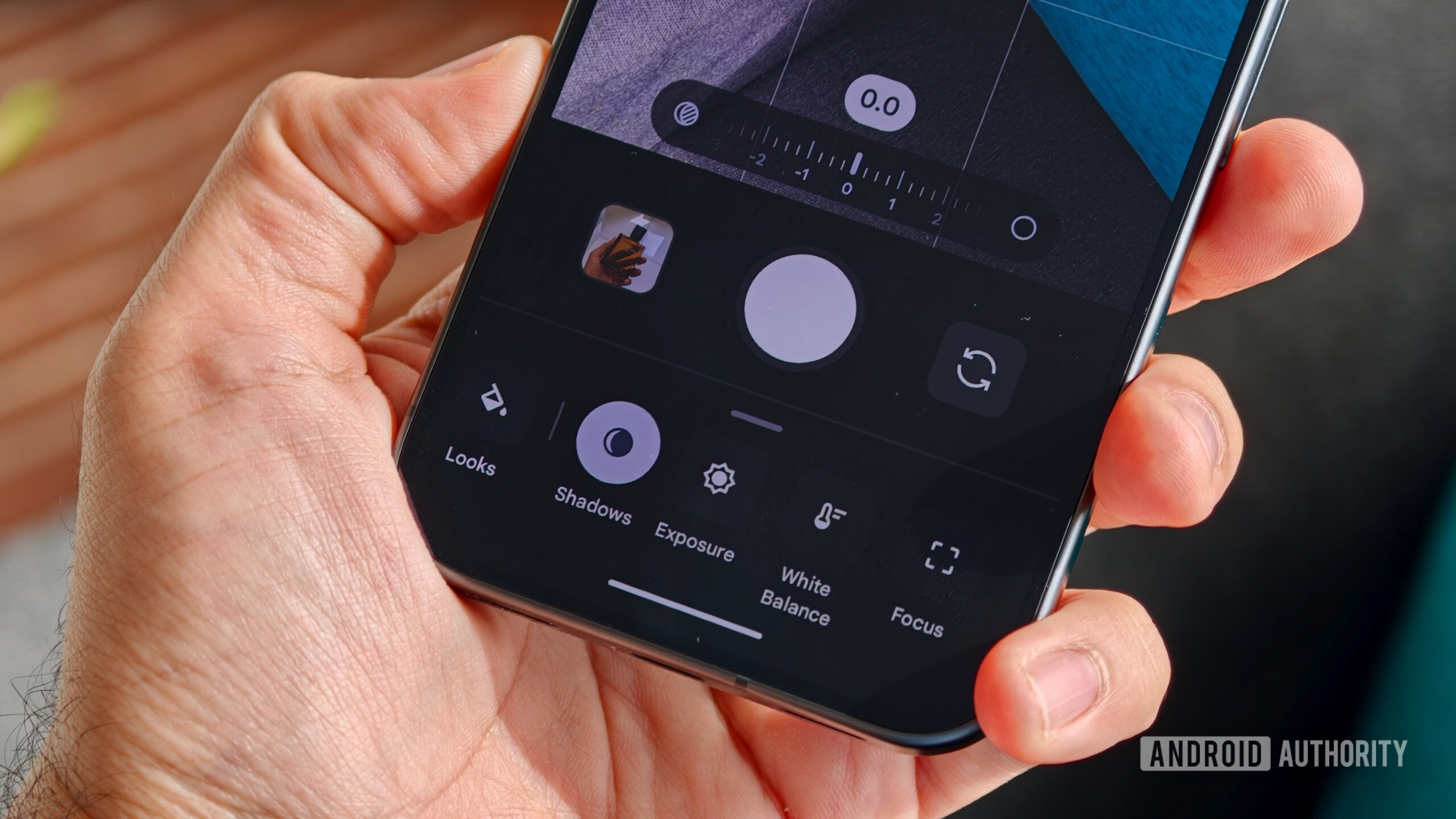 Close-up of a person holding a Google Pixel showing the camera app with manual Camera Looks open