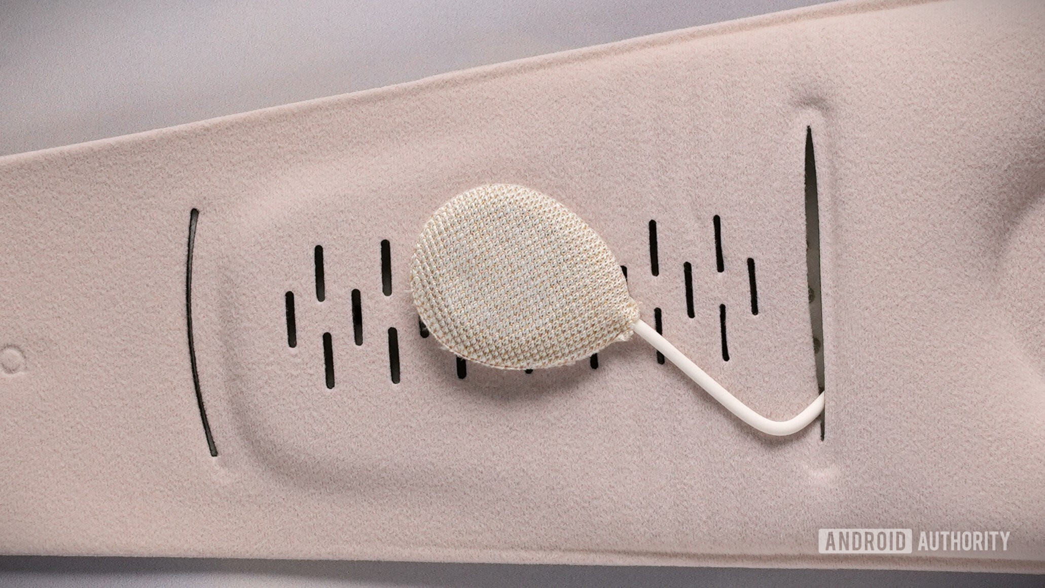Close-up of a removable fabric-covered speaker inside the Sleenova sleep mask.