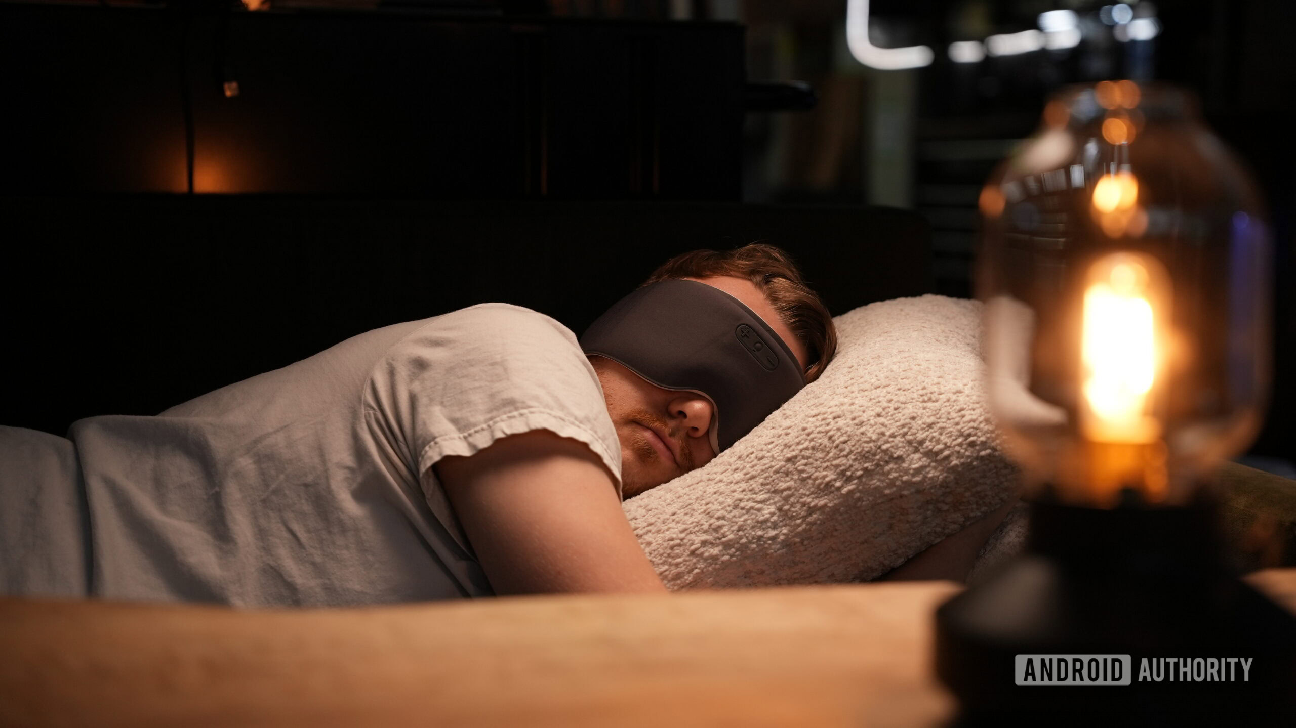 sleeping with the sleenova sleepmask (2) A side sleeper wears the Sleenova sleep mask while resting on a pillow in a dimly lit bedroom.
