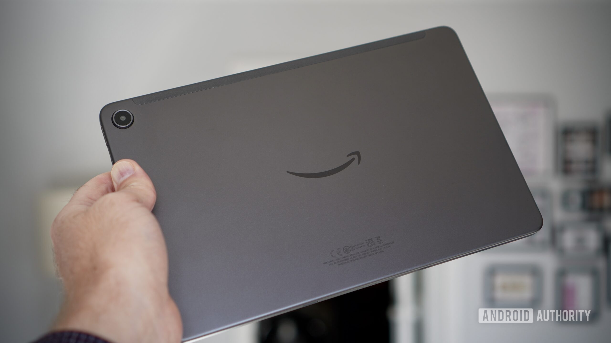 amazon fire max 11 back hand A person holding the Amazon Fire Max 11 tablet