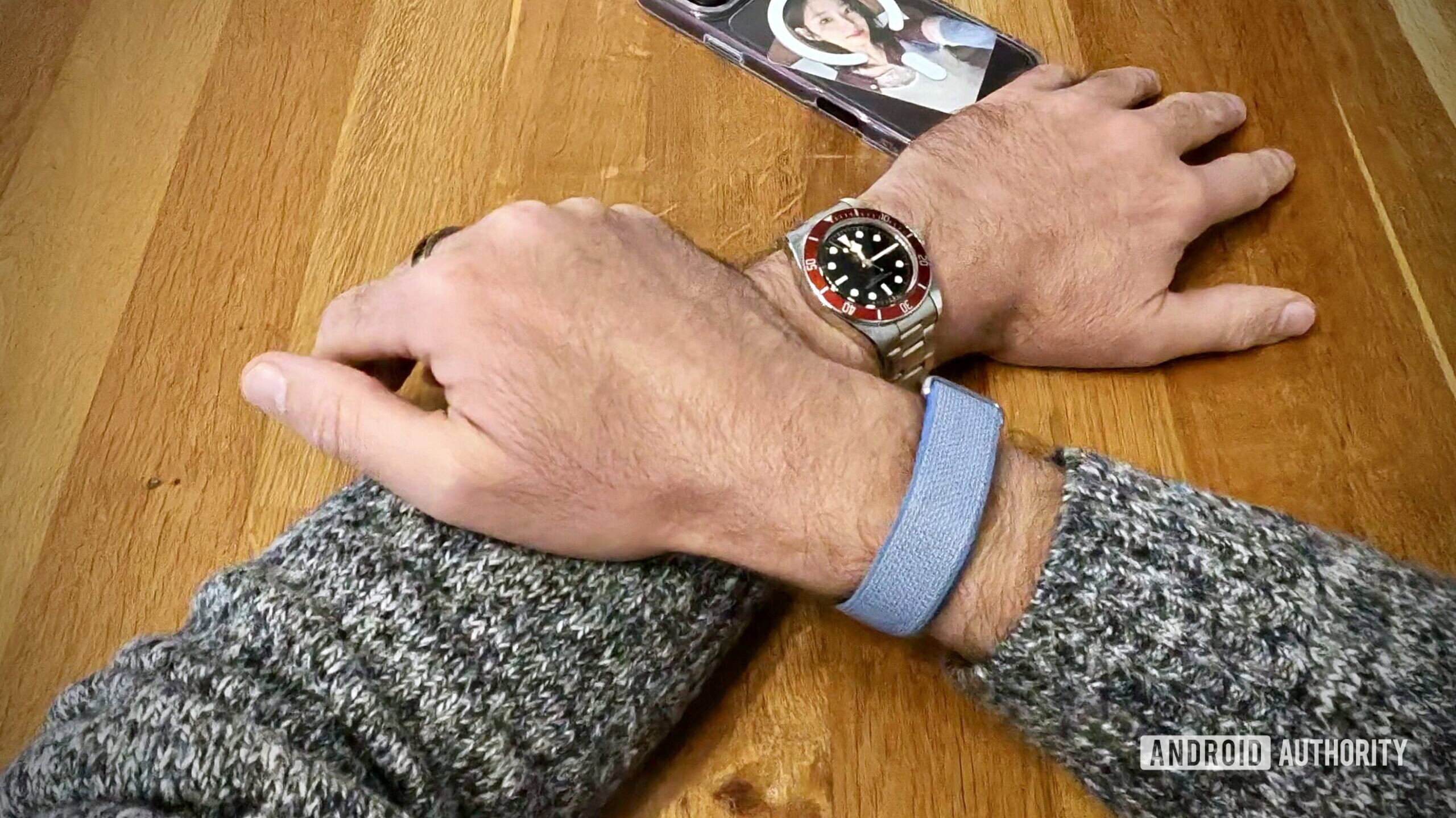 A person wearing a Fitbit Air and a regular watch.