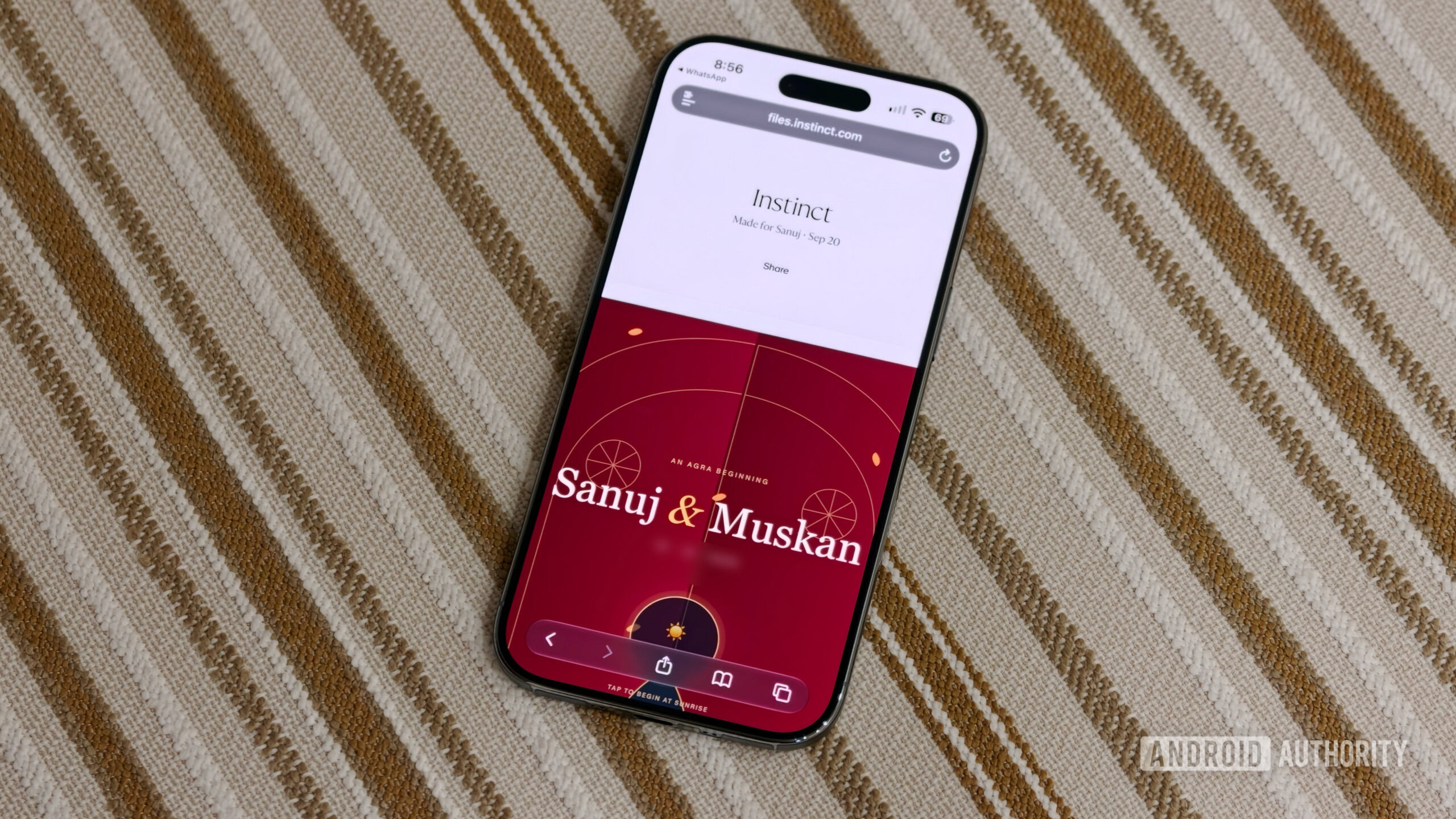 iPhone resting on a striped surface displaying a custom digital invitation webpage generated via Instinct in Safari