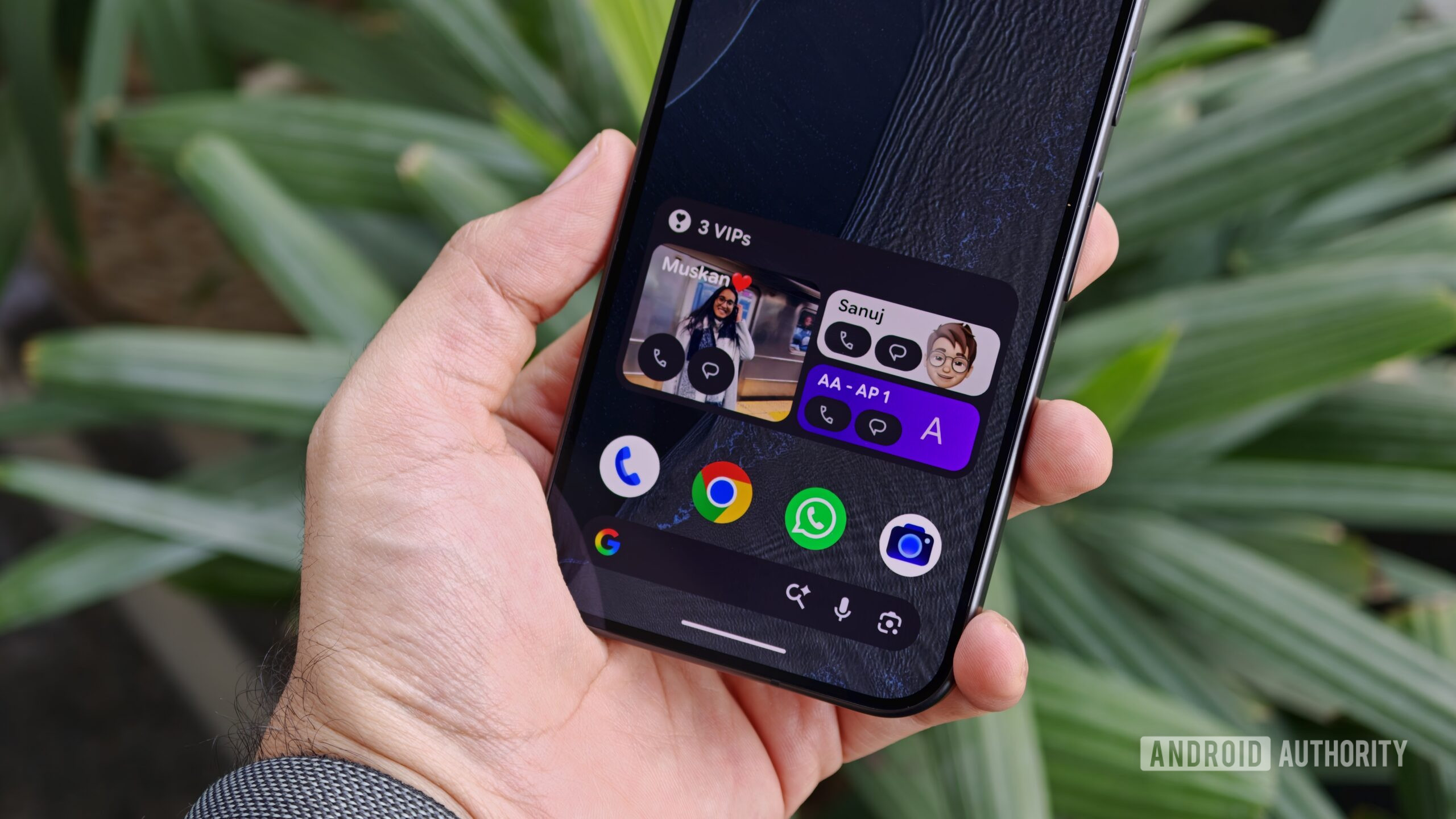 A hand holding an Android smartphone displaying the configured VIPs home screen widget with three pinned contacts
